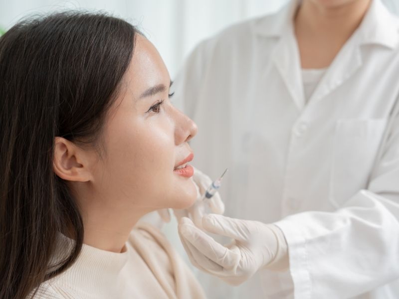 Professional dental surgeon examining a patient's teeth for cavities.