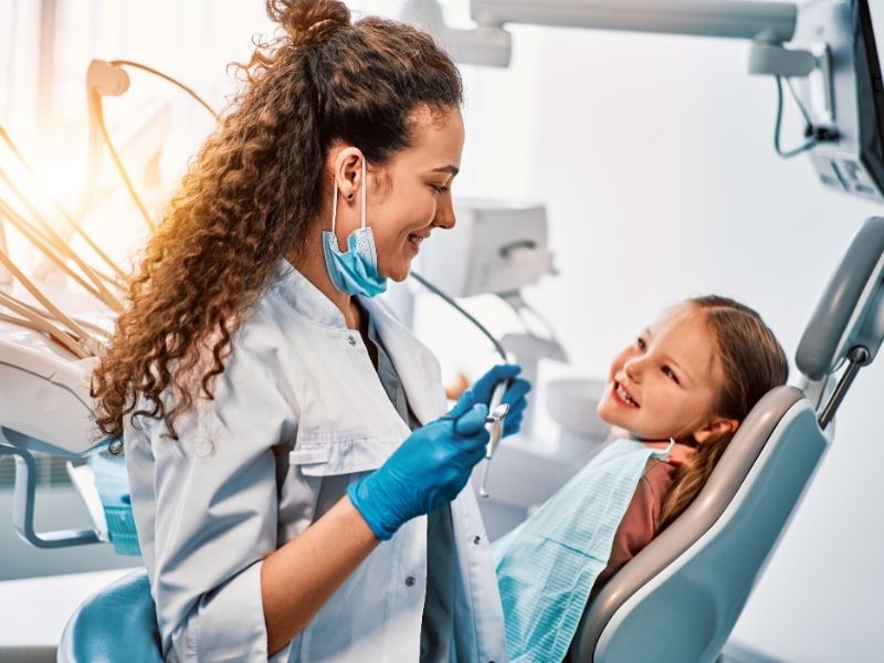 Friendly pediatric dentist providing a gentle checkup for a child.