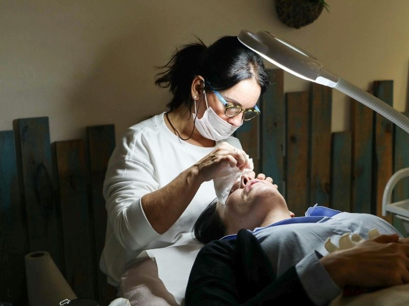 Focused dentist performing a delicate root canal procedure under high-intensity clinical lighting.